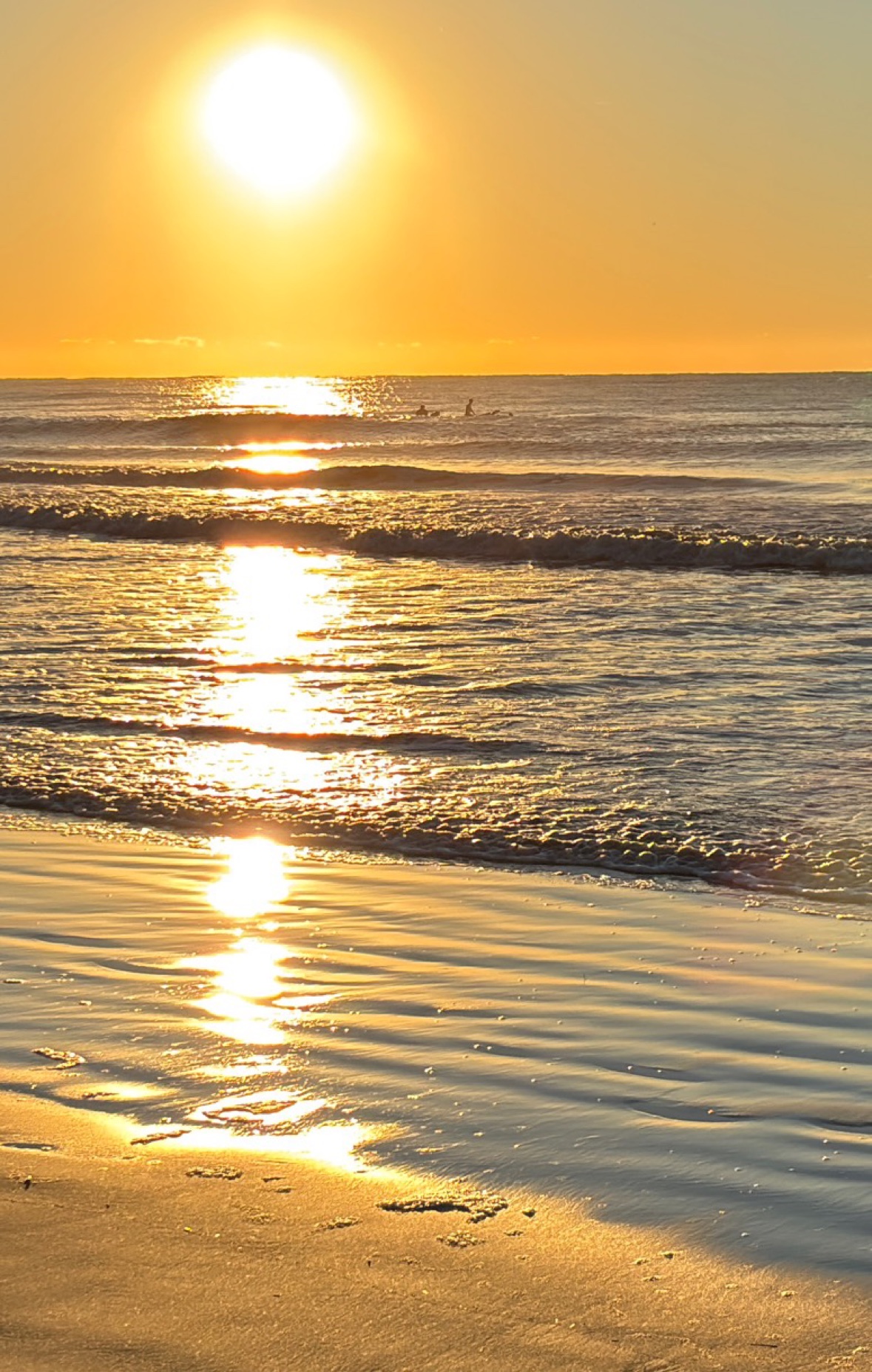Atlantic Beacon: a towering golden sunrise reflected through the surf at Folly Beach